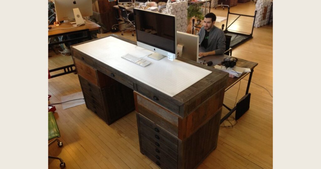 A custom standing desk in a studio, with a second desk upside down in the background.